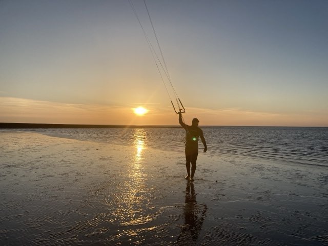 Kiter im flachen Wasser bei Sonnenuntergang