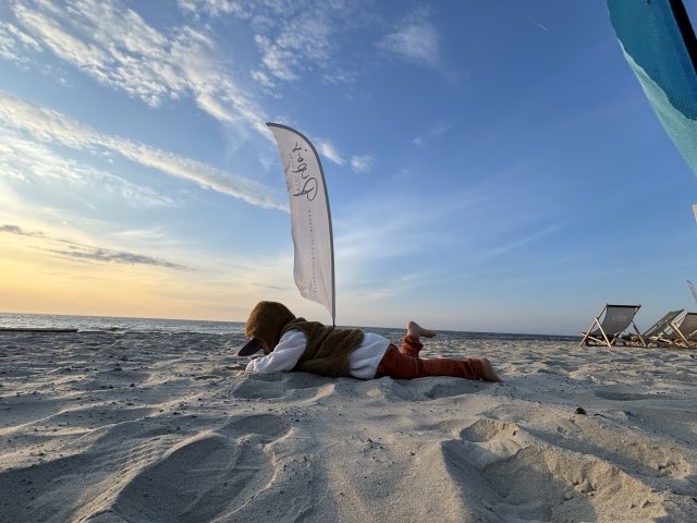 Kind im Sand vor der Bude bei Abendlicht