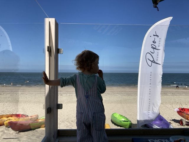 Kind auf der Terrasse mit Blick aufs Meer